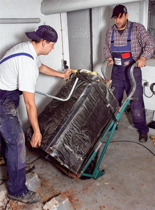 Handwerker transportieren eine alte Heizöl-Anlage ab. Die Große Koalition hat soeben das Aus für Ölheizungen beschlossen.Foto  dpa