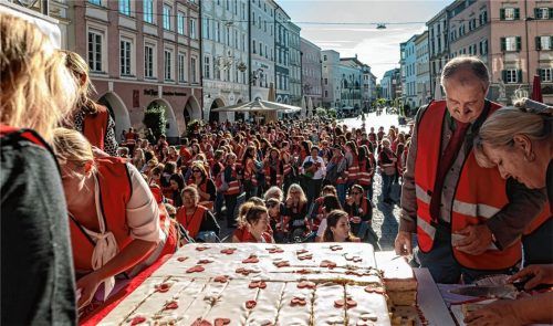 Backwerk zum 100.: AWO-Kreisvorsitzender Peter Kloo (rechts) hilft beim Verteilen der Geburtstagstorte an die Mitarbeiter und Ehrenamtlichen, die auf den Max-Josefs-Platz in Rosenheim gekommen waren. Foto Thomae