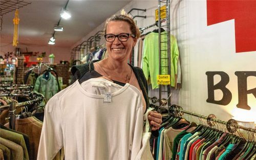 Der Secondhand-Laden in Kolbermoor bietet hochwertige Kleidungsstücke zu Schnäppchenpreisen: Teamleiterin Claudia Rieger mit einem MarkenT-Shirt für vier Euro. Fotos Thomae