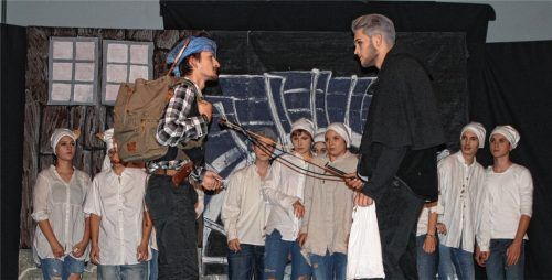 Krabat (Leonhard Schiller, rechts) und der schwarze Müller (Robert Wolf). Im Hintergrund: die zwölf Müllerburschen.Foto  Holzer