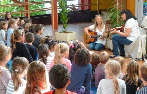 „Leseglück, da werd‘ ich fit, mach doch einfach mit!“ Hortleiterin Ingrid Dressler (links) und „Promi“-Vorleserin Marion Schnackig spielten das Lied, das sie selbst komponiert und getextet hatten.Foto Fischer