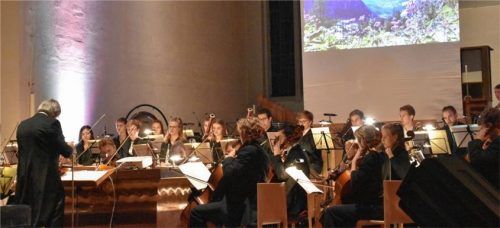 Rainer Heilmann-Mirow (links) dirigierte das Orchester. Eingeblendete Bilder veranschaulichten die Beethoven‘sche Musik. Foto Schlecker