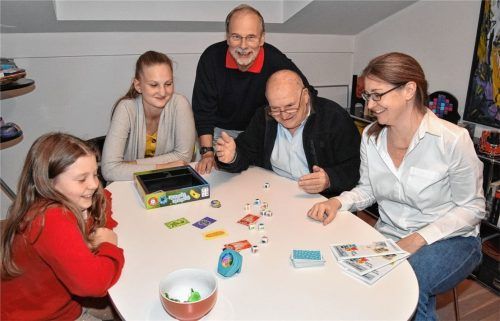 Spieleabend in Rosenheim: Spielekritiker Tom Werneck (sitzend) und Spielekritiker Chris Mewes testen Neuheiten. Unterstützung bekommen sie dabei von Miriam Antretter (von rechts), Josefa und Mirjam. Foto Schlecker