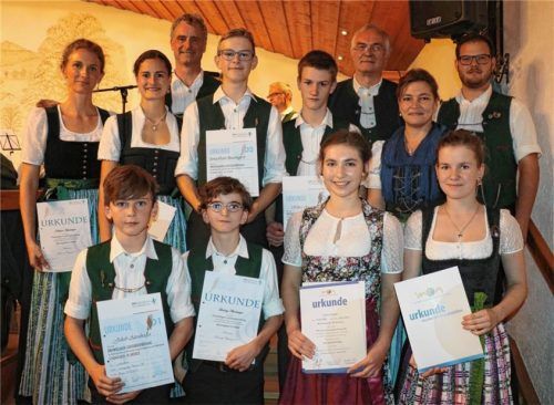 Leonhard Eisner, Vorsitzender Inn-Chiemgau des Musikbundes Ober- und Niederbayern (hintere Reihe Zweiter von rechts), der Vorsitzende der Wildenwarter Musikkapelle, Helmut Rosenwink (hintere Reihe links), und die Dirigenten der Musikkapelle, Sebastian Graf (hinten rechts), und der Jugendkapelle, Eva-Maria Gruber (davor), überreichten in der Frasdorfer Lamstoahalle die Urkunden und Abzeichen für erfolgreiche Leistungsprüfungen an acht Mädchen und Burschen der Jugendkapelle Wildenwart.Foto Rehberg