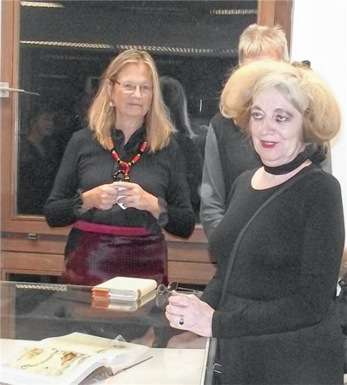 Marianne Pitzen vor der Vitrine mit den Gästebüchern, im Hintergrund Ulrike Gierlinger.