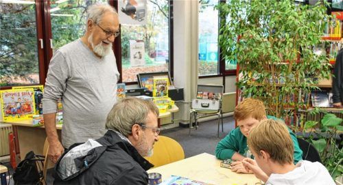Mit Begeisterung erklärt Wolfgang Wichmann (stehend) den Spielern Phil Sutherland (von links sitzend), Carlos Suther- land und Fabian Neubig das Spiel. Aus mehreren konnten die Interessierten im Haus des Buches auswählen und testen. Foto  sutherland