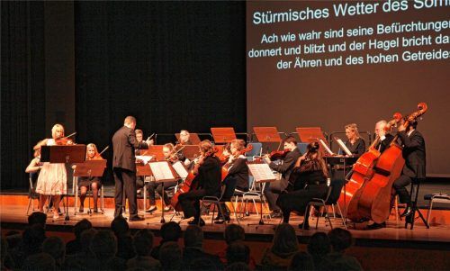 Texte auf der Leinwand: Konzertbesucher, die mit klassischer Musik nicht so vertraut sind, waren dankbar für diesen Service zu Vivaldis „vier Jahreszeiten“, die das Orchester unter Leitung von Ferenc Szelim Bene und mit der Ersten Geigerin Beatrix Bene-Godány als Solistin spielte.Foto  Von Ahn