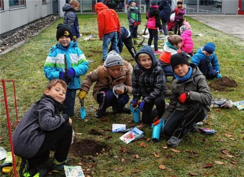 Die Grundschüler pflanzen eifrig vor dem Eingang der Mittelschule.