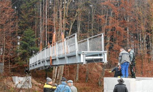 Eine Brücke über die Prien schwebt ein: 14 Tonnen Stahl wurden für das stählerne Bauwerk gebraucht, in dreieinhalb Metern Höhe überquert es künftig die Prien zwischen Dösdorf und Öd. Die Spannweite der Brücke beträgt 22 Meter.