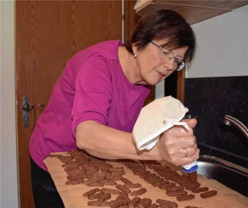 Rosi Riepertinger ist konzentriert beim Befüllen der Kakaozungen mit Gelee.