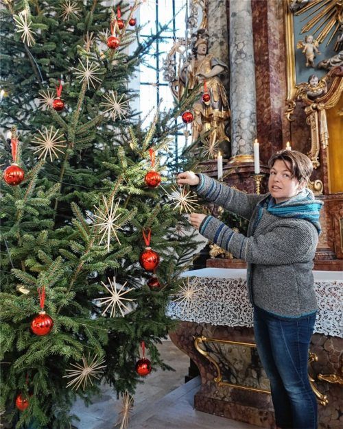 Rote Kugeln und Strohsterne: Ganz traditionell hat Margit Baumann (41) den Vagener Christbaum im Altarbereich geschmückt. Obendrein hat sie die Sitzbänke für das Kinderkrippenspiel aufgestellt und das Christkind in die hölzerne Krippe gebettet. Foto Wolf