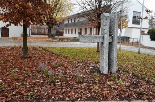 Rund um das Granitkreuz am Pfarrheim wurden Blumen gepflanzt, um die Hunde fernzuhalten.Foto Stettner
