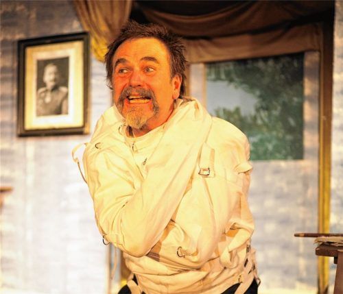 Schlüpft im „Kini-Schiaßer“ auch in die Rolle des Wittelbachers Ludwig II.: Jörg Herwegh vom Theater Herwegh in Wasserburg. Hier eine Szene mit dem entmündigten König in der Zwangsjacke.Foto Theater Herwegh