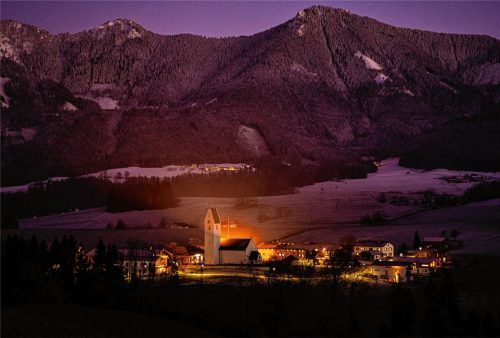 Stimmungsvoller Blick auf die Pfarrkirche in Roßholzen: Zum Jahreswechsel erstrahlt der Samerberg im abendlichen Licht in zartem Rosa. Als erste der vier Kirchen des Samerberges wird 788 die von Roßholzen urkundlich erwähnt. Zwischen 1470 und 1500 wurden die Mauern der heutigen Kirche errichtet. Die Rokokostuckierung von 1755 prägt das heutige Erscheinungsbild..Foto nitzsche