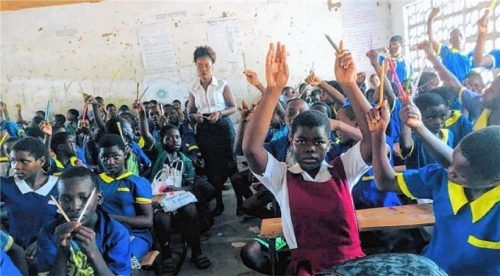 Eine Lehrkraft muss in einem engen Raum etwa 150 Kinder unterrichten. Deshalb soll das Schulgebäude erweitert werden.