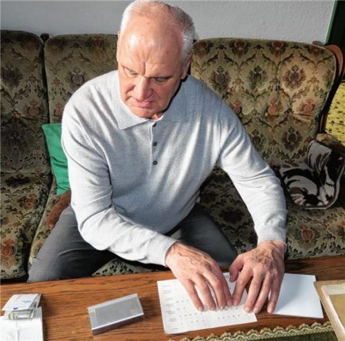 Fingerspitzengefühl: Friedrich Gerlmaier mit einem Blindenschrift-Alphabet. Foto Baumann