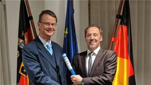 Tobias Kunst (links) vom Bayerischen Staatsministerium der Finanzen und für Heimat erhält den Staffelstab des AdV-Vorsitzes von Siegmar Liebig vom Niedersächsischen Ministerium für Inneres und Sport. Foto re