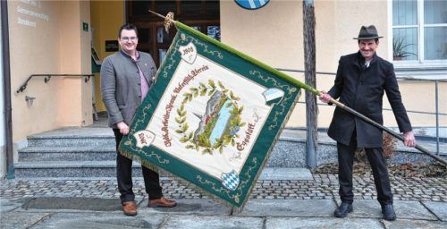 Vorsitzender Kajetan Huber (links) und Fähnrich Peter Plank präsentieren die historische Fahne.Foto Hering