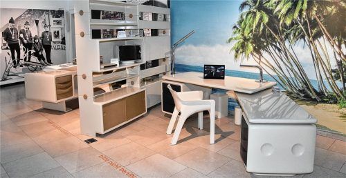 Zeitreise in der städtischen Galerie: Zu sehen ist im Vordergrund (links) eine Komar-Fototapete. Das Motiv stammt aus dem Jahr 1976. Zu sehen ist vorne im Raum zudem ein Igl-Jet-Schreibtisch, mit Igl-Chef-Regalsystem als Raumteiler. Außerdem gehören zu dem Ensemble (im Regal aufgebaut) eine Zimmerantenne, ein Fernseher und eine Überwachungsanlage von Kathrein, alle ebenfalls im Igl-Design. Foto SChlecker