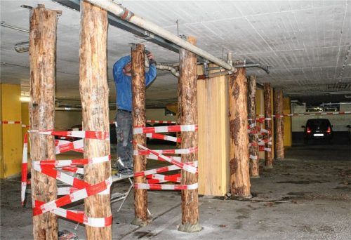 Ein unterirdischer Lärchen-Wald: 18 zusätzliche Baumstämme stützen die Tiefgaragen-Decke ab. Ein Monteur ist gerade noch damit beschäftigt, die Stämme mit Metallwinkeln an der Decke zu sichern. Zuvor wurden sie am Boden mit Quellbeton aufgefüllt. Foto  Lohmann