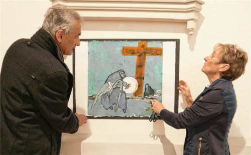 Fastenausstellung in St. Nikolaus: Unter den aufmerksamen Blicken des Hausherrn, Pfarrer Andreas Maria Zach, hängt die Unterwössener Bildhauerin und Malerin Monika Stein ihre Kreuzwegbilder auf. Foto Frick