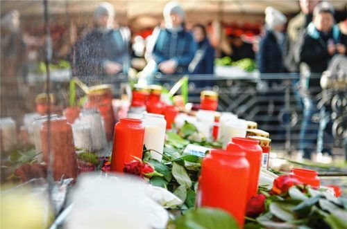 Kerzen und Blumen liegen am Brüder-Grimm-Denkmal am Marktplatz in Hanau, um an die Opfer der Bluttat zu erinnern.Foto  dpa