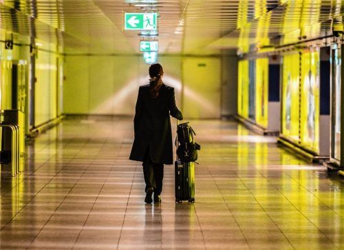 Auch der Flugverkehr ist vom Coronavirus schwer getroffen: Eine Frau geht mit ihrem Koffer durch einen leeren Gang auf dem Frankfurter Flughafen. Foto dpa