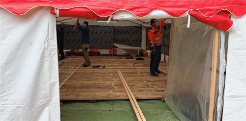 Ausgestattet mit Mundschutz und viel Elan haben Bürger und der Burschenverein ein Fieberzelt für Corona-Patienten neben der Praxis von Florian und Felix Bonke in Flintsbach aufgebaut. Foto Franz Astner