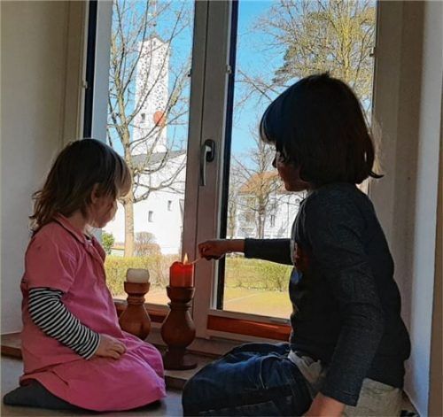 Flora und Nino, die Kinder des evangelischen Pfarrerehepaars Anita Leonhardt und Simon Stritar, zünden jeden Abend um 18.30 Uhr Kerzen, ein „Licht der Hoffnung“, an.Foto re