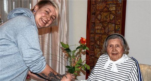 Floristin Verena Hoogvliet, Inhaberin von Blütenzauber in Prutting, als Rosenkavalier. Hier überreicht sie der Jubilarin Adi Balk die Rose „Atomic“.Foto Ammelburger