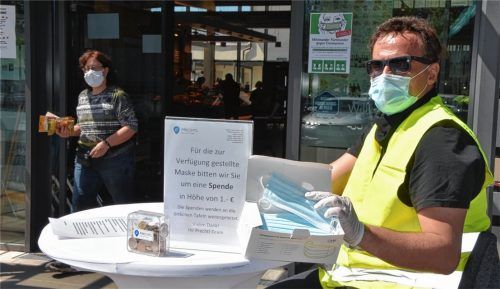 Ein Euro pro Maske: Roy Konzack vom Sicherheitsdienst Cult Crew gibt Kunden, die keinen Mund-Nase-Schutz dabei haben, vor einem der Prechtl-Märkte eine Einweg-Maske. Der Erlös kommt den Tafeln, mit denen Prechtl zusammenarbeitet, zugute. Gestern war der erste Tag der Maskenpflicht im Landkreis Rosenheim. Foto Ruprecht
