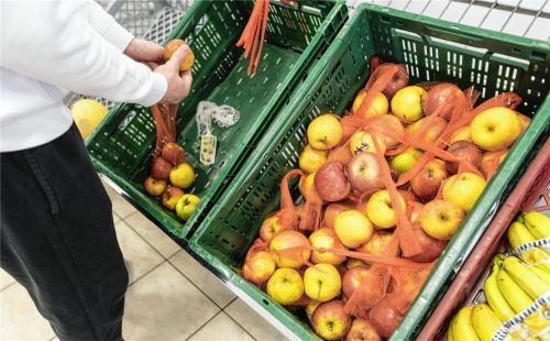 Ein Mitarbeiter der Tafel füllt eine Kiste mit Äpfeln auf. In Kiefersfelden will man weiterhin für die Bedürftigen da sein. „Die Leute brauchen diese Unterstützung!“Foto DPA