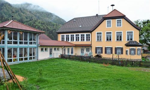 Blick auf den Kindergartenanbau und die Alte Schule in Niederaudorf. Coronabedingt verändert sich die Einnahmesituation der Gemeinde Oberaudorf. Der Gemeinderat hat deshalb den Beschluss auf Neubau eines Kindergartens auf dem Heimfeld (ehemaliges Hallenbadgelände) aufgehoben.Foto Lotter