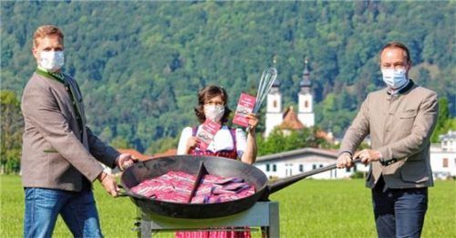Bürgermeister Simon Frank (links) zusammen mit Tourismuschef Herbert Reiter (rechts) und Katja Vordermayer (Mitte) von der Tourist-Info rühren in der riesigen Bratpfanne des Natur-Freischwimmbades die druckfrischen Genussführer richtig um.Foto re