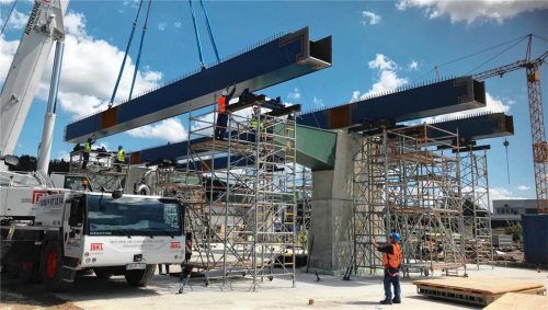 Das Einheben der Stahlteile beim Bau der neuen Aicherparkbrücke erforderte schweres Gerät und viele Mitarbeiter auf der Baustelle, die mitanpacken.Foto Staatliches Bauamt Rosenheim