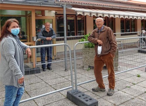 Die Brüder Albin und Erhard Höll (rechts) probten schon mal die neue Möglichkeit des Angehörigen-Besuches – wenn auch noch durch einen Zaun getrennt. Monika Michl, Mitarbeiterin im Adalbert-Stifter-Heim, freut sich, dass die Bewohner wieder ihre Angehörigen sehen können. Foto  Andrea Engelmann