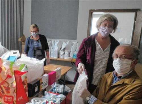 Einblicke in die Arbeit während der Corona-Krise: Die Ehrenamtlichen (von links) Petra Bauer, Annemarie Denavs und Ernst Kirchhoff packen die Tüten.
