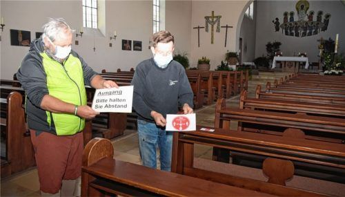 Kirchenpfleger Christian Mareth (links)und Mesner Christian Förster bringen diverse Markierungen in der Heilig Kreuz Kirche Raubling zu den Vorgaben an.Foto Ruprecht