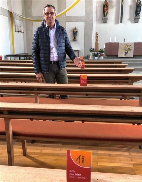 Platzanweiser: Daniel Reichel zeigt, wie mit Sitzkärtchen der Abstand in der Kirche gehalten werden kann. Foto privat