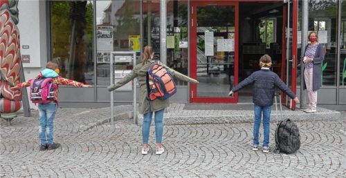 Sicherheitsabstand und Maskenpflicht: Rektorin Astrid Sauer begrüßt die Viertklässler am Eingang der Preysing-Grundschule. Die Schüler dürfen nach acht Wochen „Zwangspause“ wieder in die Schule, nächste Woche sollen die Erstklässler folgen.Fotos elk