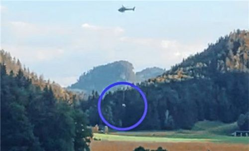 An einem Seil wird die tote Kuh (blauer Kreis) per Hubschrauber von der Weide ins Tal geflogen. Foto Gruber