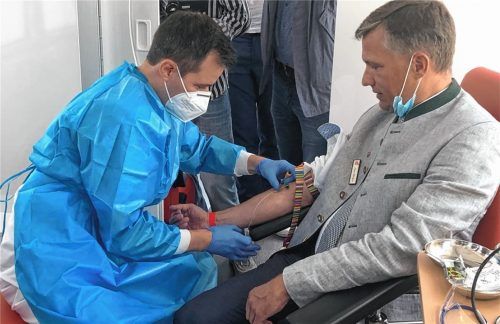 Bad Feilnbachs Bürgermeister Anton Wallner war der erste Bürger, der in einem der beiden Untersuchungsbusse des RKI durch Studienmitarbeiter Nicu Anghel (links) den Rachenabstrich und die Blutentnahme für die Studie vornehmen ließ. Foto  Lagler