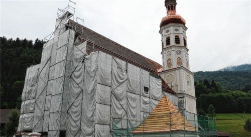Der Kirchturm der Pfarrkirche St. Michael in Sachrang ist bereits von den weißen Planen befreit. Jetzt muss noch die Außenfassade am Kirchengemäuer erneuert werden. Foto rehberg