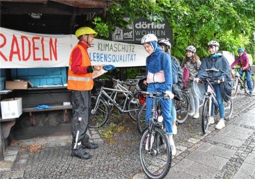 Ein Dankeschön für 155 Radfahrer, die sich auch bei kräftigem Regen nicht vom Drahtesel abbringen ließen, gab es vom Radverkehrsbeauftragten der Gemeinde Stephanskirchen, Frank Wiens (links) und Mitstreitern jetzt am Schloßberg. Nicht nur verbal, sondern auch in Form von Regenüberzügen, Flickzeug und Reflektorbändern. Foto Schlecker