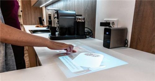 Ein mobiler Beamer erlaubt den Zugriff auf das Internet. Die Schaltflächen werden etwa auf die Arbeitsplatte projiziert und dort einfach mit Gesten gesteuert. Foto AMK