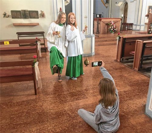 Natalie Lauricella (links) und Magdalena Franke zeigen wie es nicht geht: Beim Ministrieren sind keine Sandalen und keine Gaudi erlaubt. Aurelia Franke filmt die beiden Oberministrantinnen. Foto Weinzierl