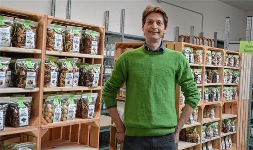 Paranüsse, schokolierte Mandeln, Trockenobst und Co. in plastikfreie Folie – den Nachhälter – verpackt. Grünkunft-Chef Christoph Kleber in seiner Produktionshalle in Rott am Inn. Die befüllten Holzkisten heißen „Displays“ und sind fertig für den Verkauf. Sie kommen mit einer Hartfaserplatte verschlossen beim Kunden an und können direkt so aufgestellt werden.Fotos Klemm