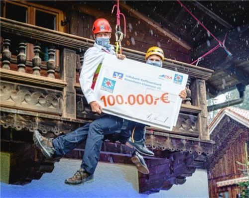 Die Volksbank Raiffeisenbank lässt die Bergwacht nicht hängen: Hubert Kamml (links) übergibt den überdimensionalen Spendenscheck angeseilt in luftiger Höhe an Andreas Basler von der Bergwacht. Foto Richard Egger