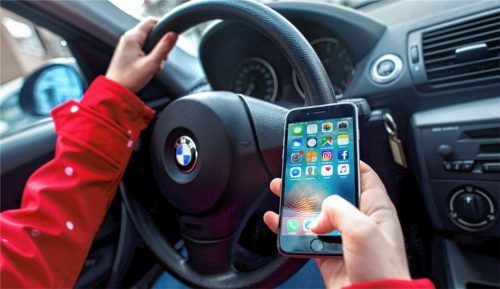 Gefährliche Ablenkung: Der Blick auf das Smartphone während der Fahrt. Foto dpa