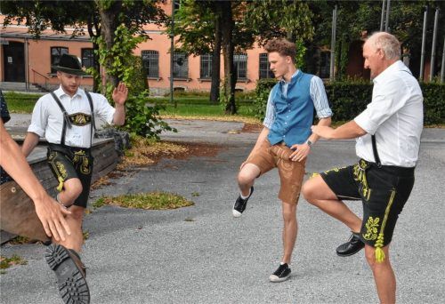 Sieht einfach aus, ist es aber nicht: Kursleiter Lukas Licht (links) und Thomas Spranger (rechts) vom Rosenheimer Trachtenverein „D’Innviertler“ zeigen den Kursteilnehmern des Plattlerkurses wie OVB-Reporter Kilian Schroeder, wie‘s richtig geht.